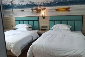 A hotel room with two beds, a mural of a mountain landscape, and a nightstand with a lamp. - Huilong Hotel (Sihui)