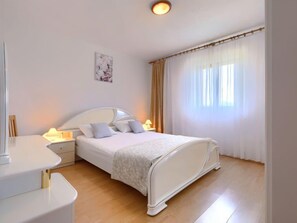 Une chambre à coucher bien rangée, avec un lit, des tables de chevet et une lampe de chevet.