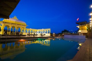 Enjoy a serene evening by the pool, surrounded by the hotel's unique architecture.