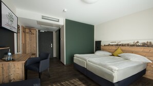 A hotel room with a bed, a desk, and a chair. There is a wardrobe and a door leading to another room. - Hotel Zum Grünen Baum (Ellwangen)