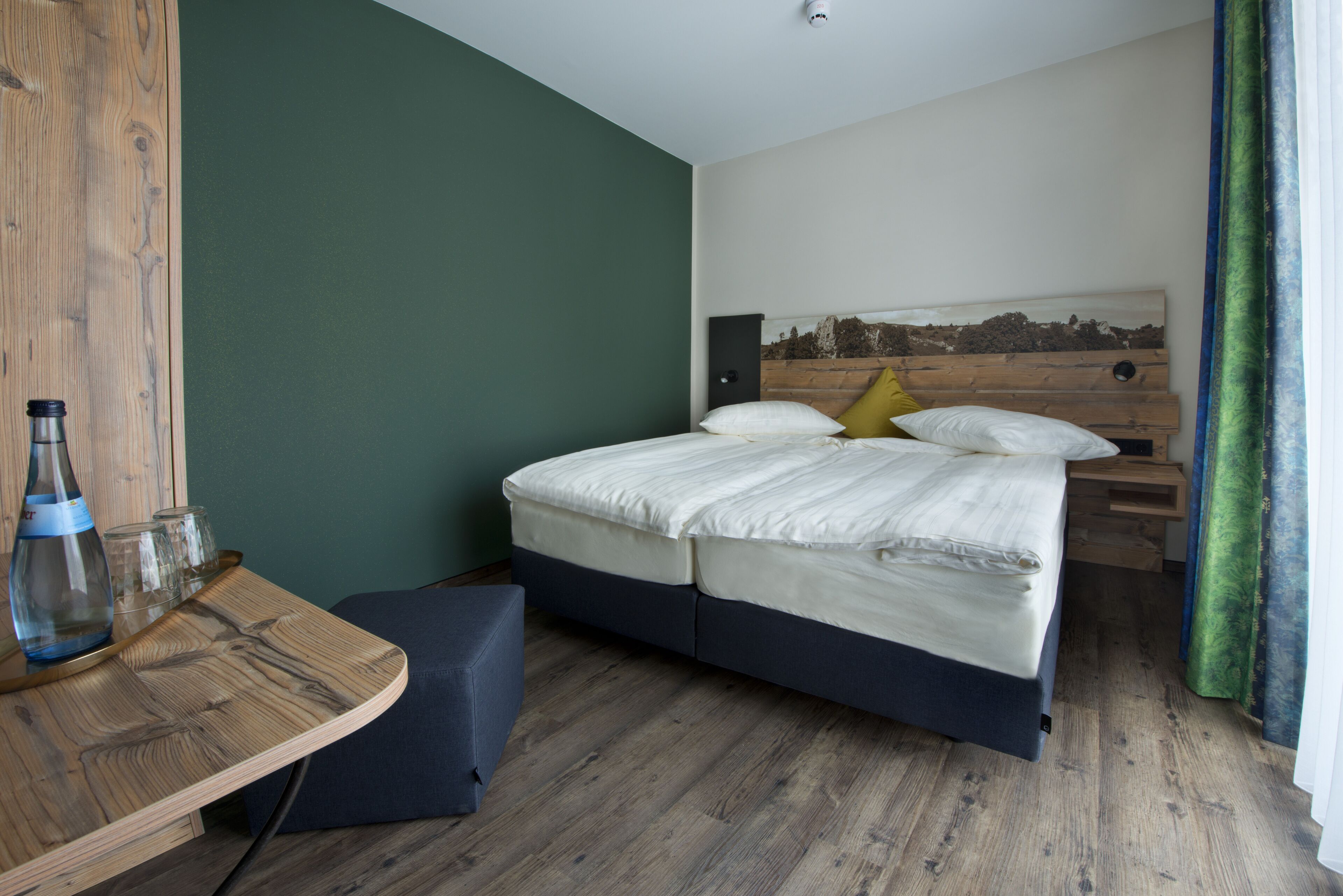Un dormitorio con cama, mesita de noche y una pequeña zona de estar.
