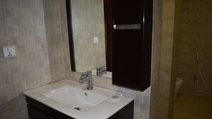 A bathroom with a white sink, dark vanity, and a mirror above the sink. - PINE VIEW HOTEL (Mekhtar)