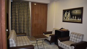 A living room with a sofa, armchairs, a small table, and a wardrobe. - PINE VIEW HOTEL (Mekhtar)