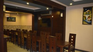 A restaurant with wooden tables and chairs, a painting on the wall, and a 'No Smoking' sign. - PINE VIEW HOTEL (Mekhtar)