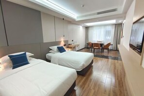 A hotel room with two beds, a desk, a chair, and a TV. - Zengdu Hotel (Suizhou)