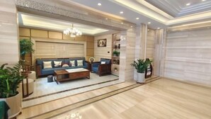 Un hall moderno con un conjunto de sofás, una mesa de centro y plantas decorativas.