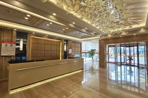 A hotel reception area with a modern design, including a reception desk, seating area, and a decorative ceiling. - Zengdu Hotel (Suizhou)