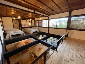 Una habitación tradicional japonesa con suelo de tatami, vigas de madera y puertas correderas shoji.