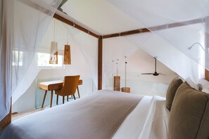 A bedroom with a large bed, a desk, and a chair. - Sun & Moon Villa (Canggu)