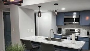A modern kitchen with a central island, stainless steel appliances, and pendant lighting. - Eastside 3 bed 2 bath, King en suite & fast Wifi (El Paso)