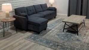 A modern living room with a sectional sofa, two side tables with lamps, a wooden coffee table, and a patterned rug. - Eastside 3 bed 2 bath, King en suite & fast Wifi (El Paso)