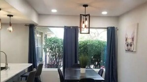 A modern dining area with a long table, chairs, and a potted plant. - Eastside 3 bed 2 bath, King en suite & fast Wifi (El Paso)