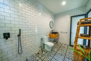 Een aparte badkuip en douche, een haardroger, handdoeken, zeep