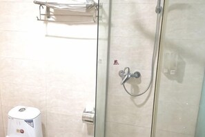 A glass shower enclosure with a handheld showerhead, a towel rack above, and a trash bin to the left. - Taishan Hotel (Hukou)