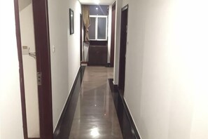 A hallway with a door on the left, a window with curtains, and a door on the right. - Taishan Hotel (Hukou)