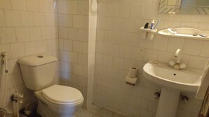 A bathroom with a toilet, sink, and tiled walls. - Hotel Al Bader (Mekhtar)