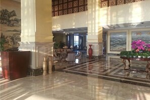 A lobby with a marble floor, a reception desk, and a dining area. - Haishanghai Hotel (Xingcheng)