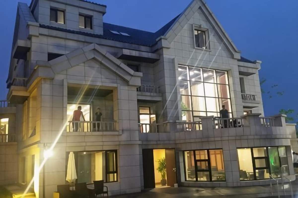 A multi-story building with balconies, large windows, and a prominent entrance.