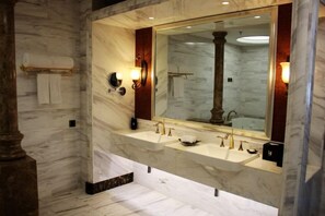 A marble bathroom with a large mirror, two sinks, and a towel rack. - Haishanghai Hotel (Xingcheng)