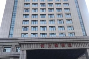 Un edificio de varios pisos con una cuadrícula de ventanas y un letrero con caracteres chinos.