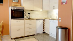 A compact kitchen with a built-in oven, a coffee maker, and a dishwasher.