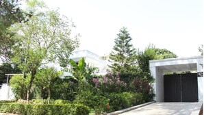 A residential area with a gated entrance, lush greenery, and modern buildings in the background. - Rio Inn West (Mekhtar)