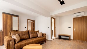 Un salon moderne avec un canapé marron, une table basse en bois et un grand miroir.