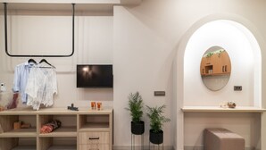 A modern bathroom with a vanity, mirror, and potted plants.