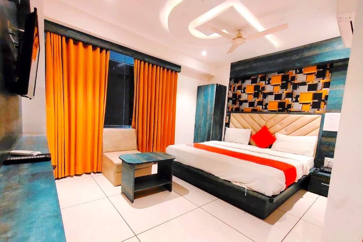 Una habitación de hotel moderna con una cama, una mesita, un sofá y un televisor.