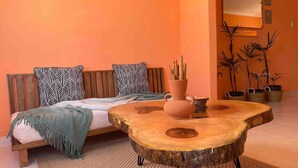 A cozy room with a wooden sofa, a round wooden coffee table, and a woven rug. - Casa Durazno - Beautiful 3 Bed in Santo Domingo (Los Alcarrizos)