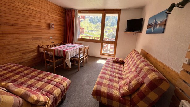 Une chambre avec deux lits, une table à manger et un téléviseur.