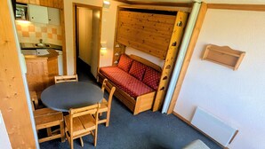 A compact living space with a kitchenette, a dining area, and a sofa. - Divisible studio at the foot of slopes with balcony, pets allowed (Plagne Aime 2000)