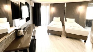 Una habitación de hotel con cama, escritorio, televisor y ventana.