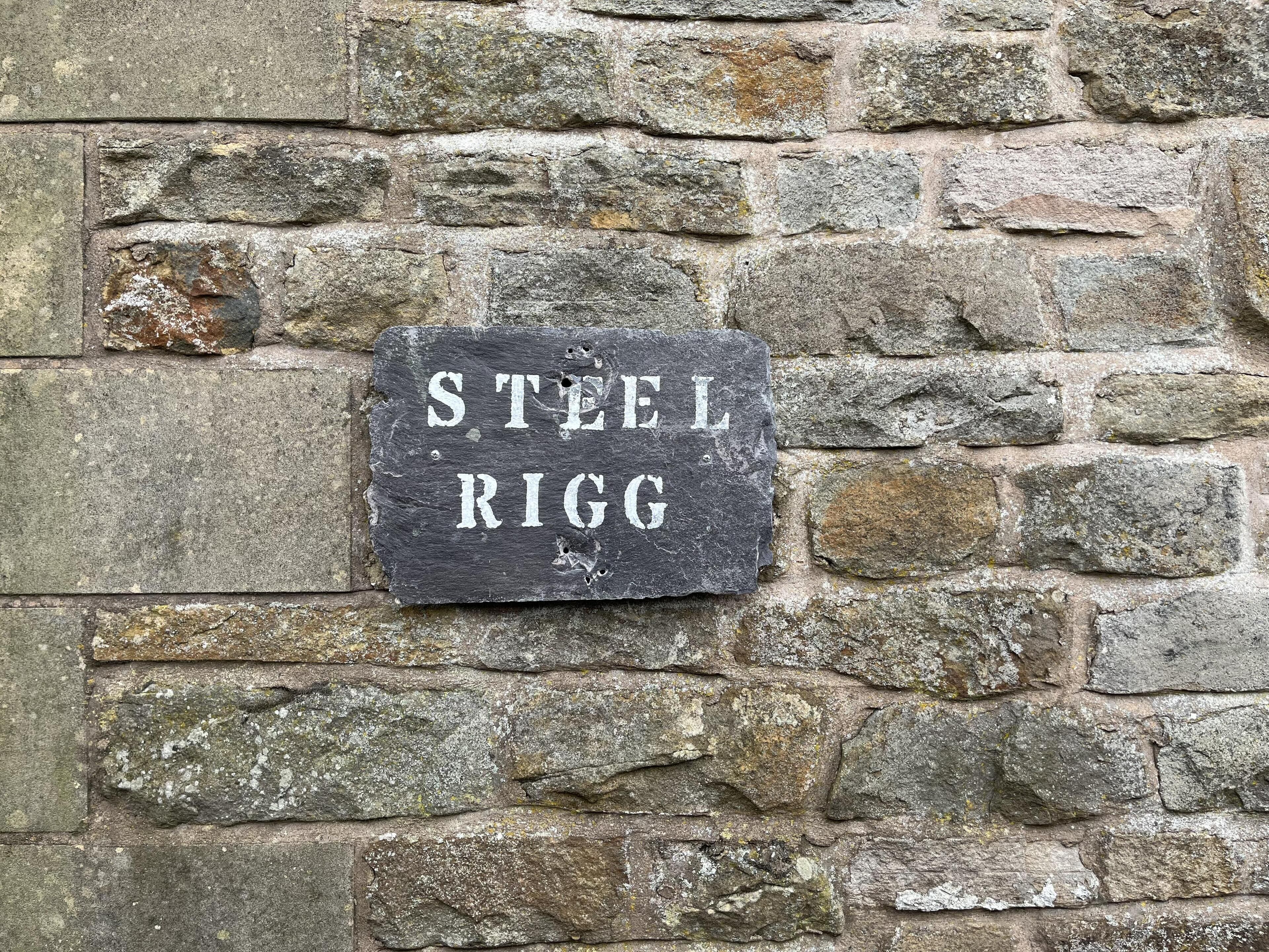 Kivimuuri, jossa on kyltti, jossa lukee: ”STEEL RIGG”.
