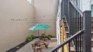 A courtyard with outdoor seating and string lights.