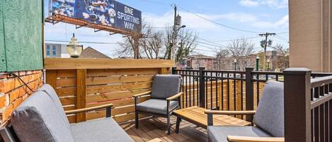 An outdoor seating area with wooden furniture and a view of the cityscape.