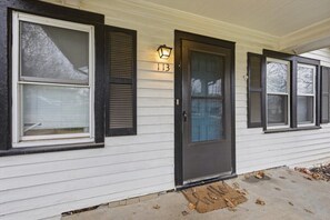 A house with a black front door, a number '113' above it, and a light fixture on the wall. - Waldo Craftsman - Fenced yard + Walkable to dining (Kansas City)
