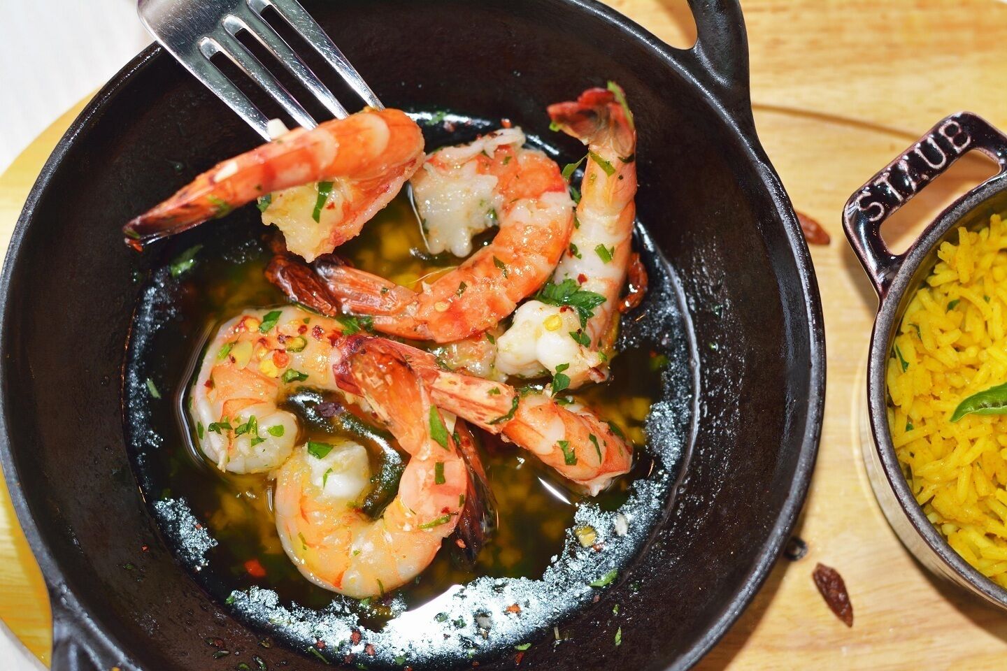 A skillet with cooked shrimp and rice.
