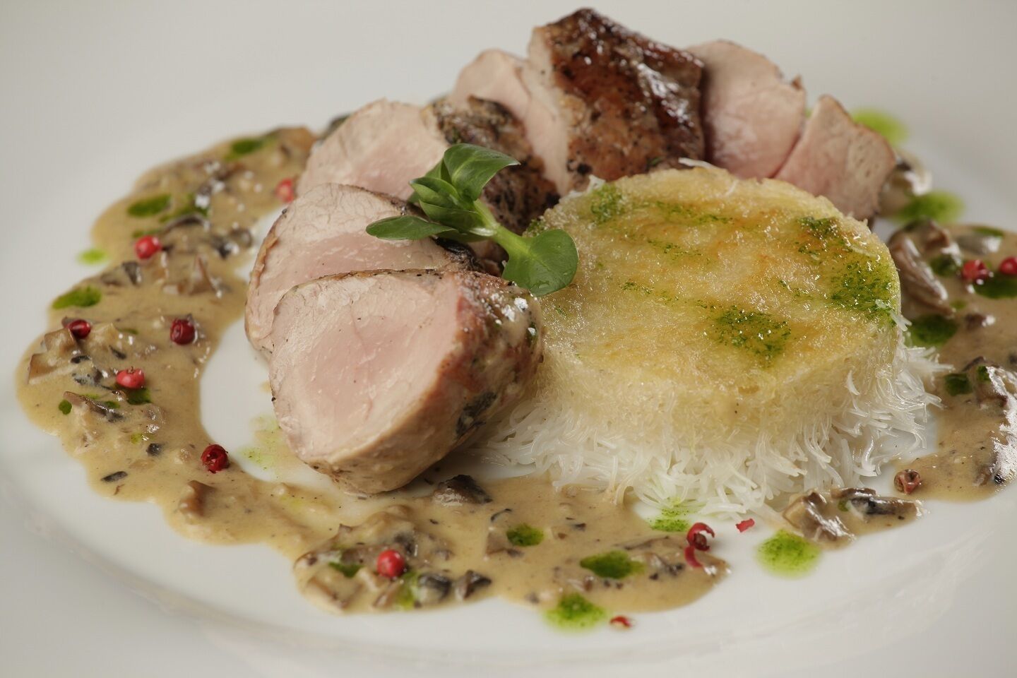 A plate of sliced meat with a creamy sauce and a mound of rice.
