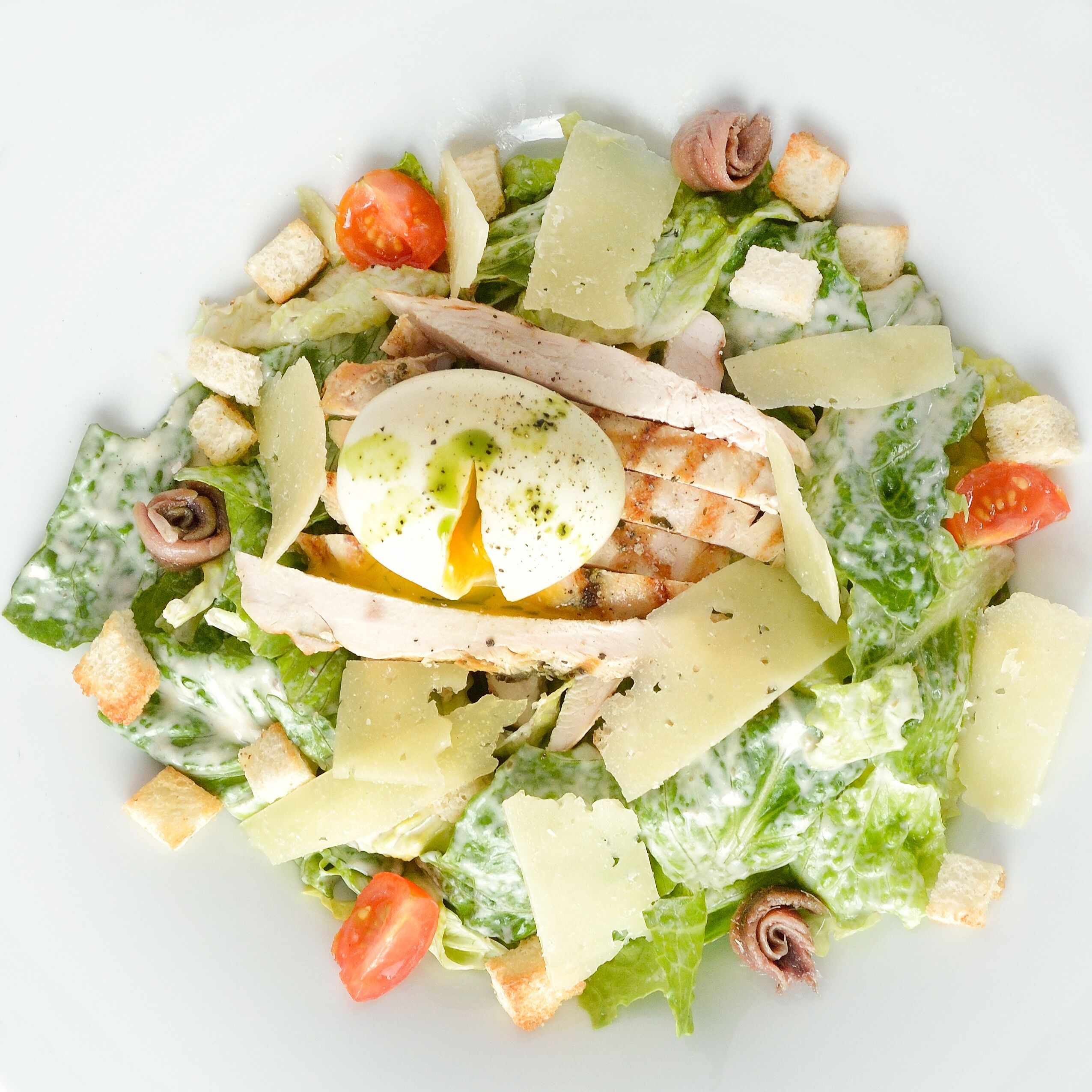 A salad with lettuce, tomatoes, croutons, and cheese.
