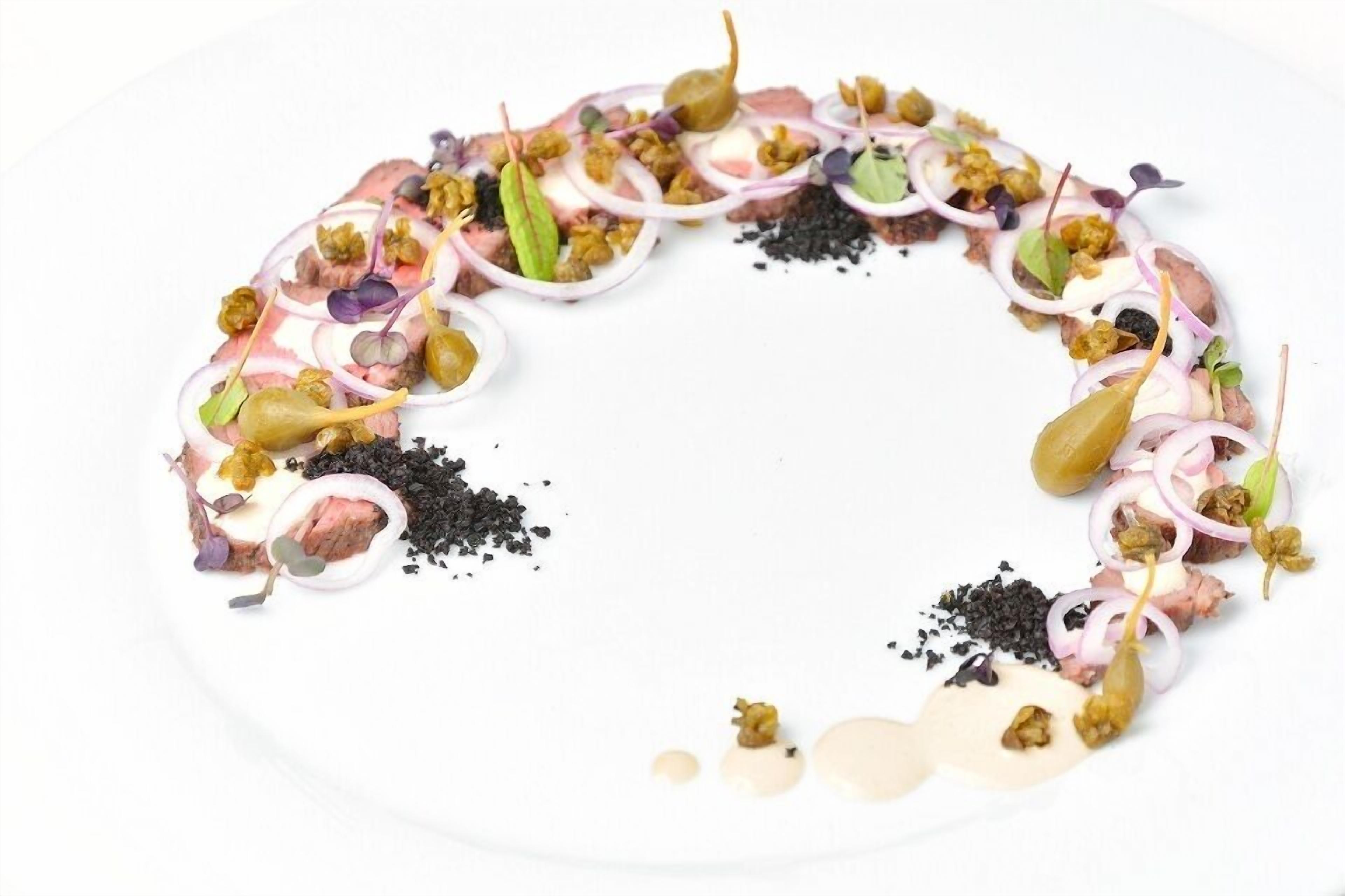 A white plate with a variety of food items arranged in a circular pattern.