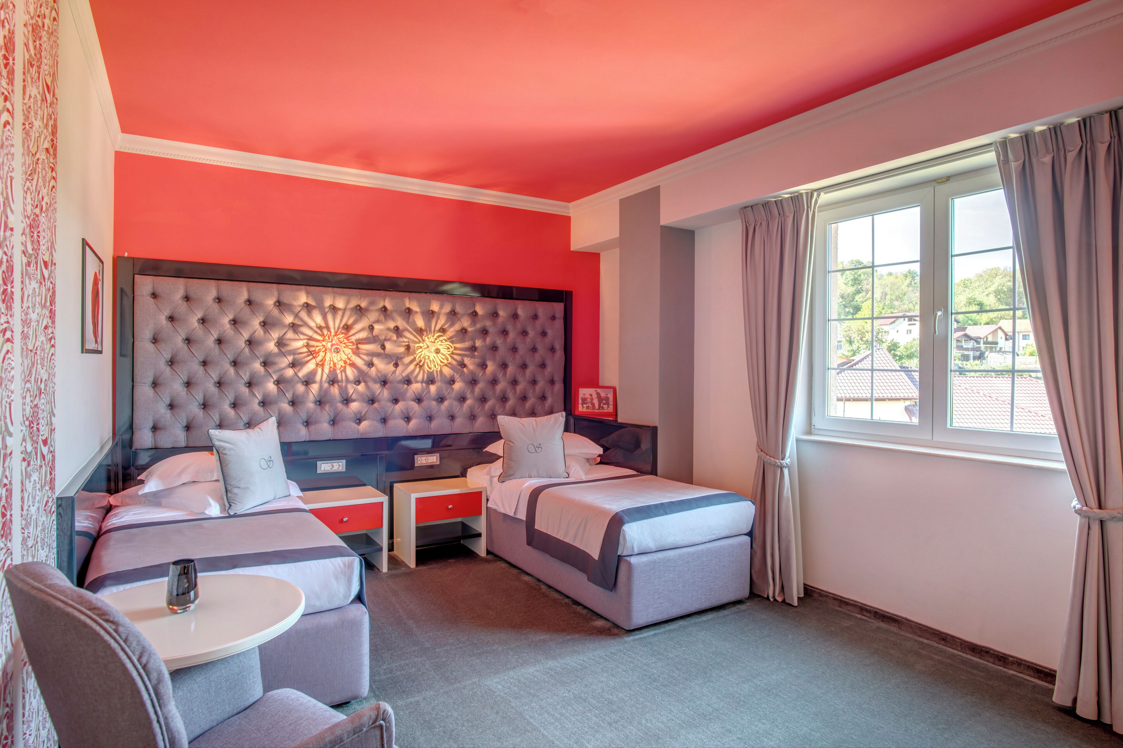 Una habitación de hotel con una cama grande, una cama más pequeña, un escritorio y una silla.