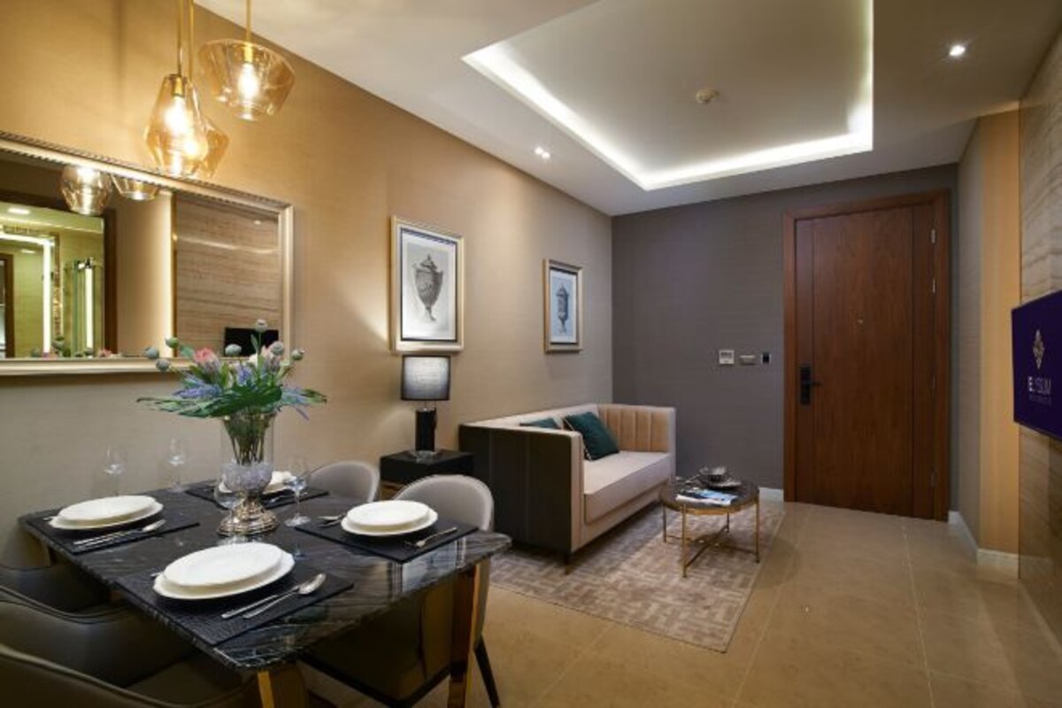 A modern living room with a dining area, a sofa, a coffee table, and a TV.