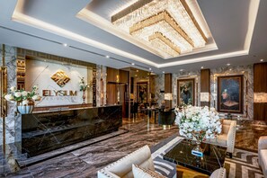 A luxurious lobby with a marble reception desk, elegant seating, and a chandelier. - The Elysium Pratumnak Pattaya - By SHG (Pattaya)