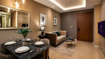 A modern living room with a dining area, a sofa, a coffee table, and a TV.