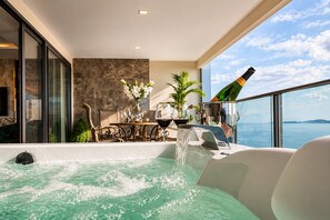 A rooftop bar with a hot tub, dining area, and a view of the sea. - The Elysium Pratumnak Pattaya - By SHG (Pattaya)