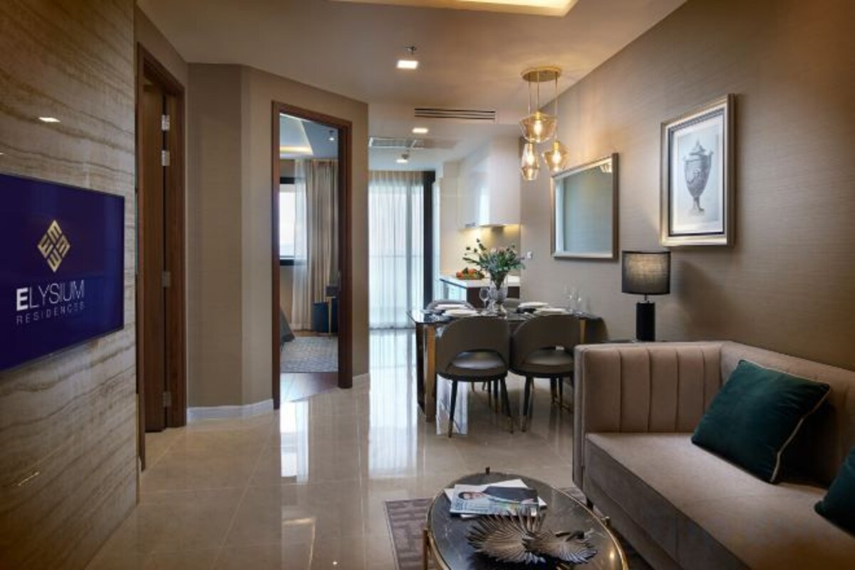 A hotel lobby with a reception desk, a sofa, and a dining area.