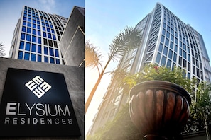 Un edificio moderno con un letrero que indica Elysium Residences.