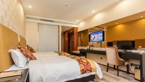 Una habitación de hotel con cama, escritorio, silla, televisor y ventana con persianas.