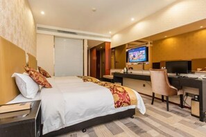 A hotel room with a bed, desk, chair, TV, and a window with blinds. - Guanzhong Hotel (Tongguan)